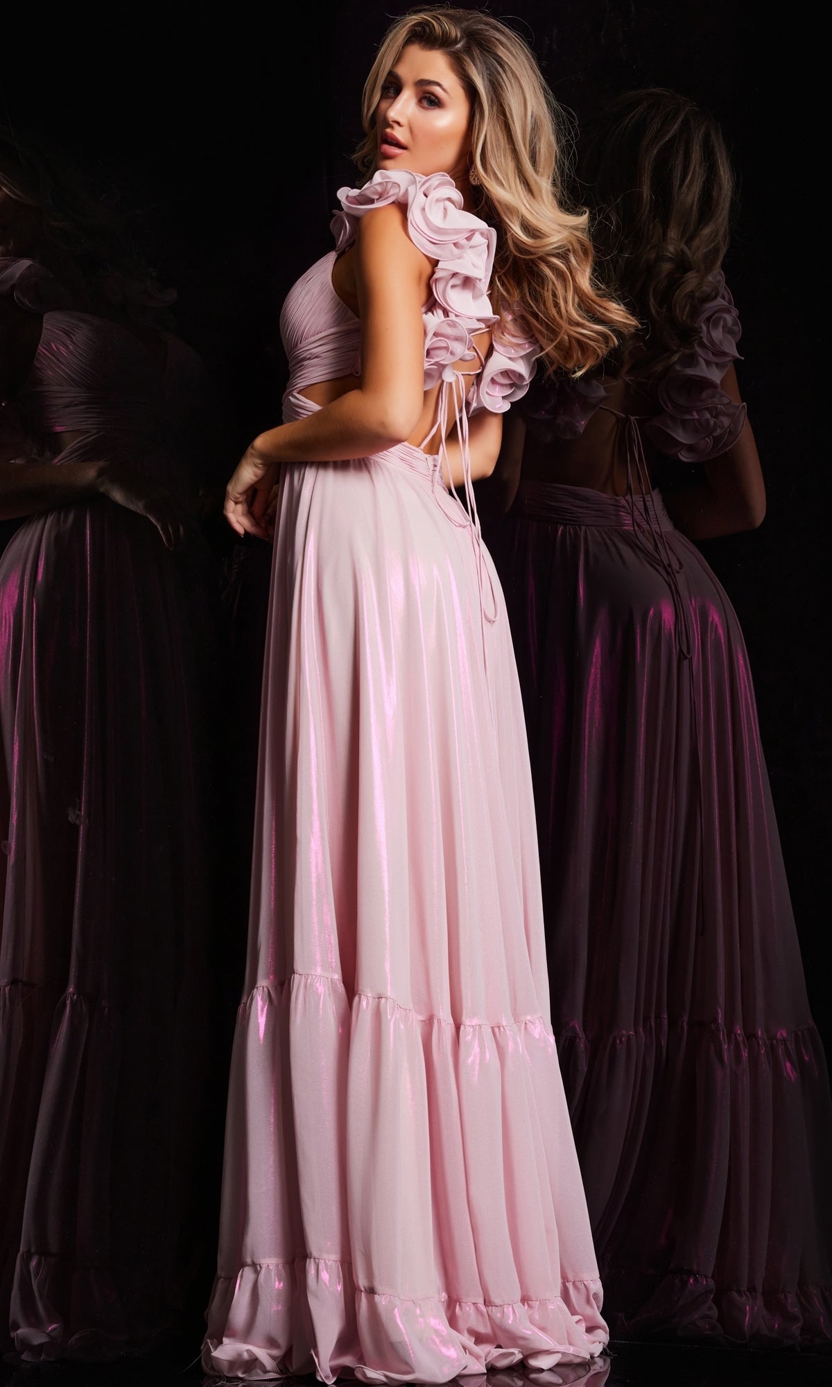 A woman radiates elegance in a long pink gown, reminiscent of the Jovani Ruffle-Strap Long Metallic Prom Dress 26248.